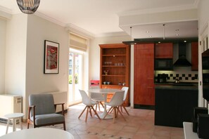 A modern kitchen with a built-in microwave, a black range hood, and a wooden cabinet.