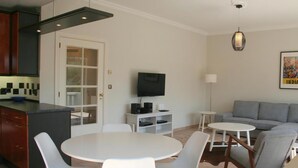 A modern living space with a kitchen, dining area, and a sofa.