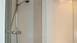 A bathroom with a shower, a sink, and a mirror.