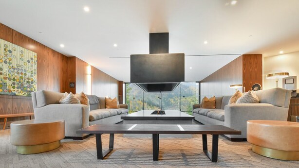 Una sala de estar moderna con dos sofás, una mesa de centro y un televisor grande.