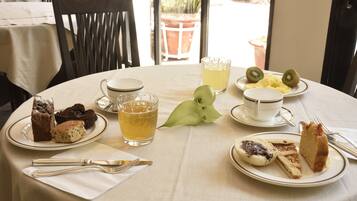 A table set for a meal with various desserts and a beverage.