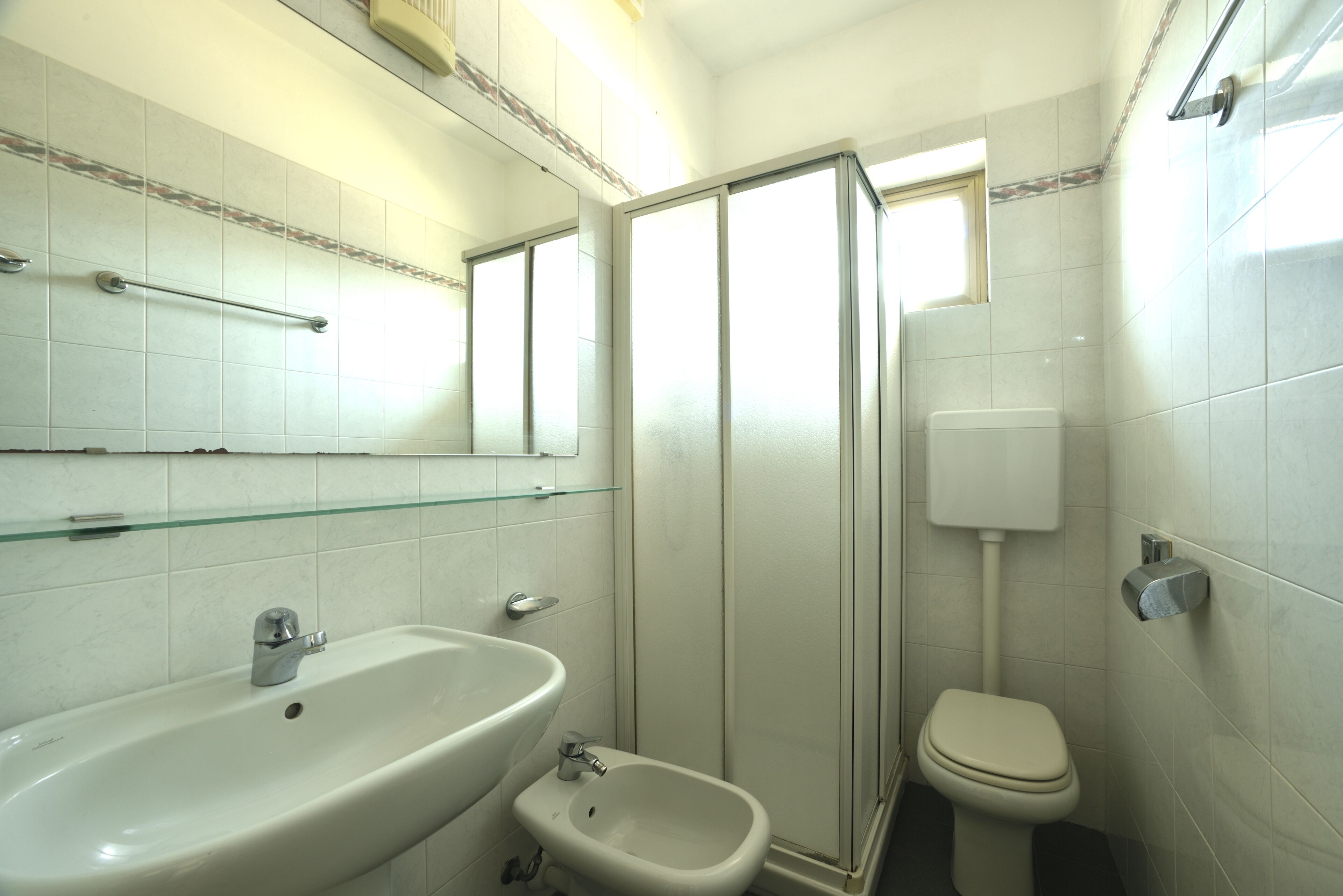 Ein Badezimmer mit Waschbecken, Bidet, Toilette und Duschkabine.
