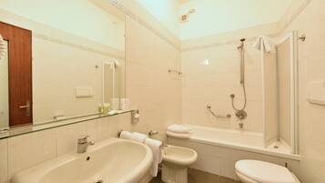 A bathroom with a large sink, a toilet, a bidet, and a bathtub.