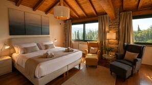 A bedroom with a large bed, a chair, a table, and a view of the outdoors. - Villa Gran Paradiso (Toscolano-Maderno)