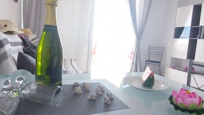 Ein Zimmer mit einem Bett, einem Tisch, einer Flasche, Gläsern und einem dekorativen Gegenstand.
