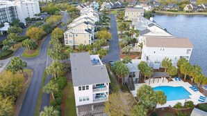 A residential area with a swimming pool, a two-story house with a balcony, and a road curving through the neighborhood.