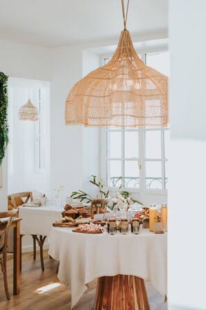 A dining area with a round table set for a meal, surrounded by chairs. - La Brise (Roscoff)