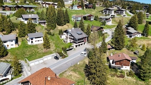 Un quartier résidentiel avec des maisons, des rues et une chaîne de montagnes en arrière-plan.