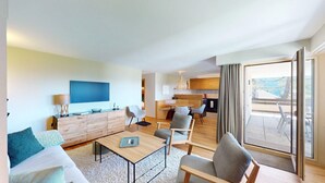 Une chambre d’hôtel moderne dotée d’un espace de vie, d’une table à manger et d’une cuisine.