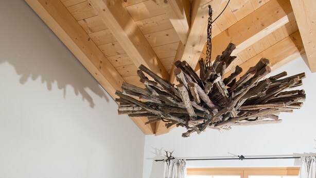 Un dormitorio con una cama grande, techo de madera y vistas a través de un ventanal.