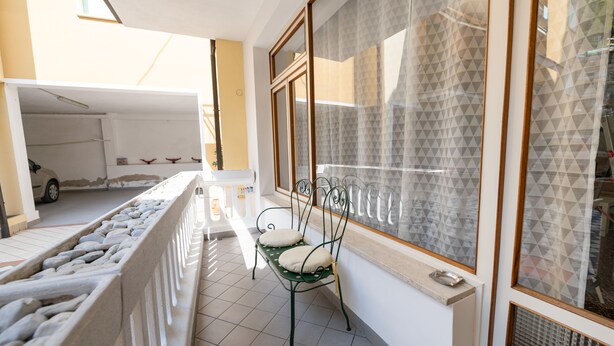 Un balcon avec une chaise et une vue sur un garage.