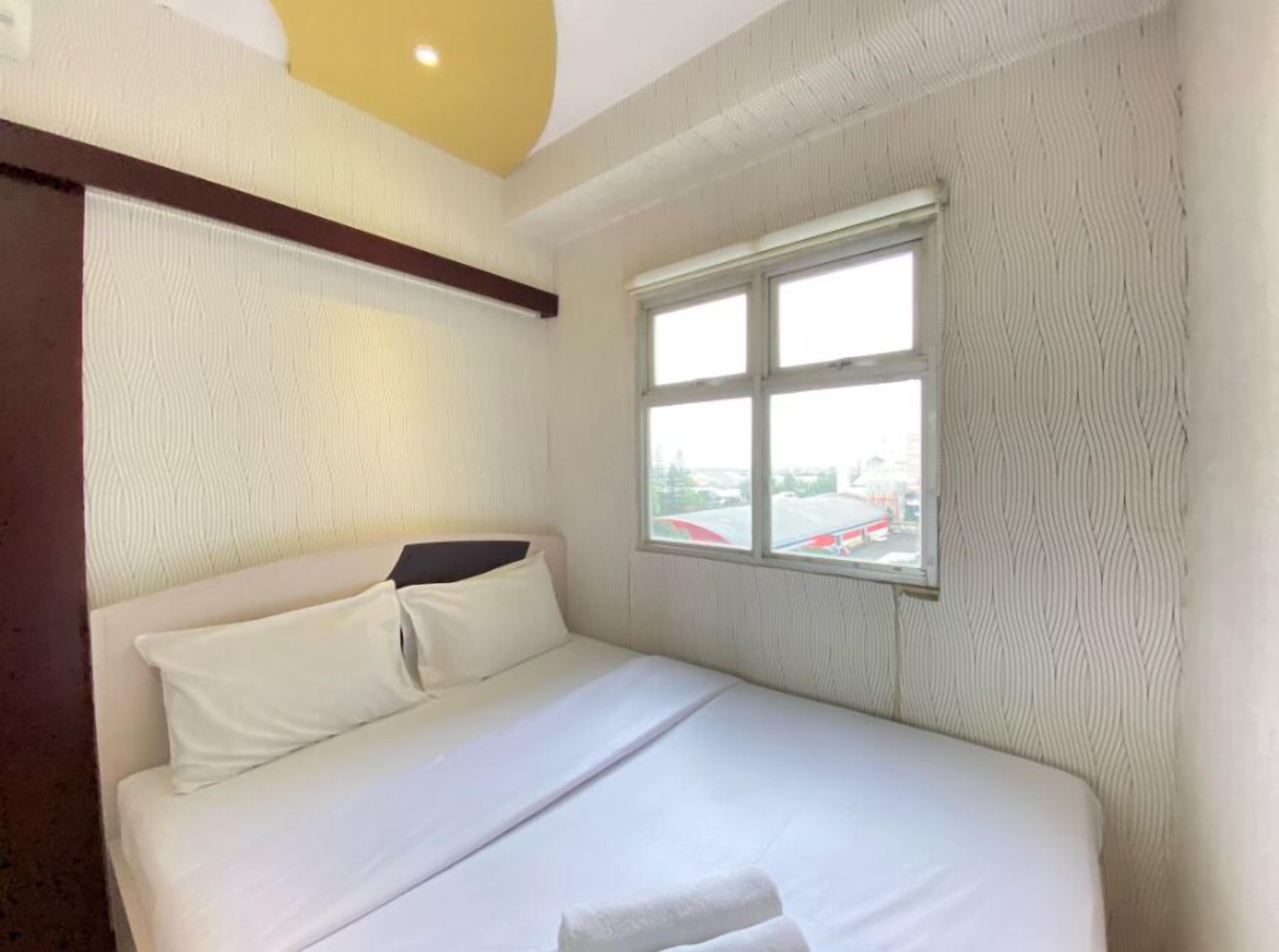 A hotel room with a bed, a window, and a view of the outside.