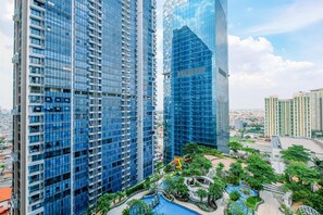 Un ensemble immobilier composé d’immeubles de grande hauteur à plusieurs étages, avec une cour intérieure dotée d’une piscine et entourée de verdure.