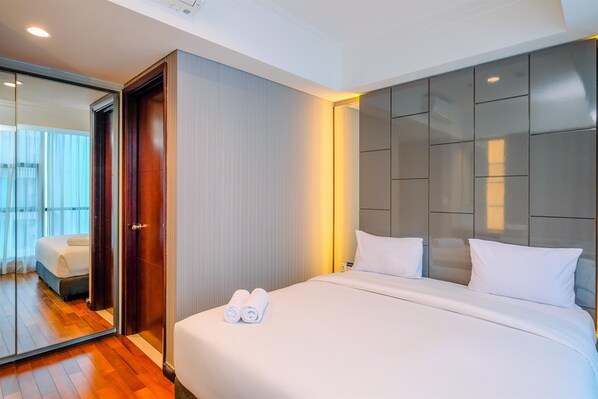 Une chambre d’hôtel moderne avec un grand lit, un miroir et une vue sur le balcon.