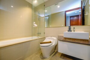 Une salle de bain moderne avec une douche à parois de verre, des toilettes blanches et un lavabo doté d’un plan de travail en marbre.