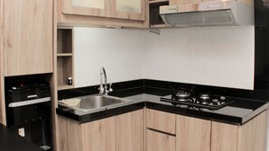 A modern kitchen with wooden cabinets, a stainless steel sink, a gas stove, and a built-in oven.