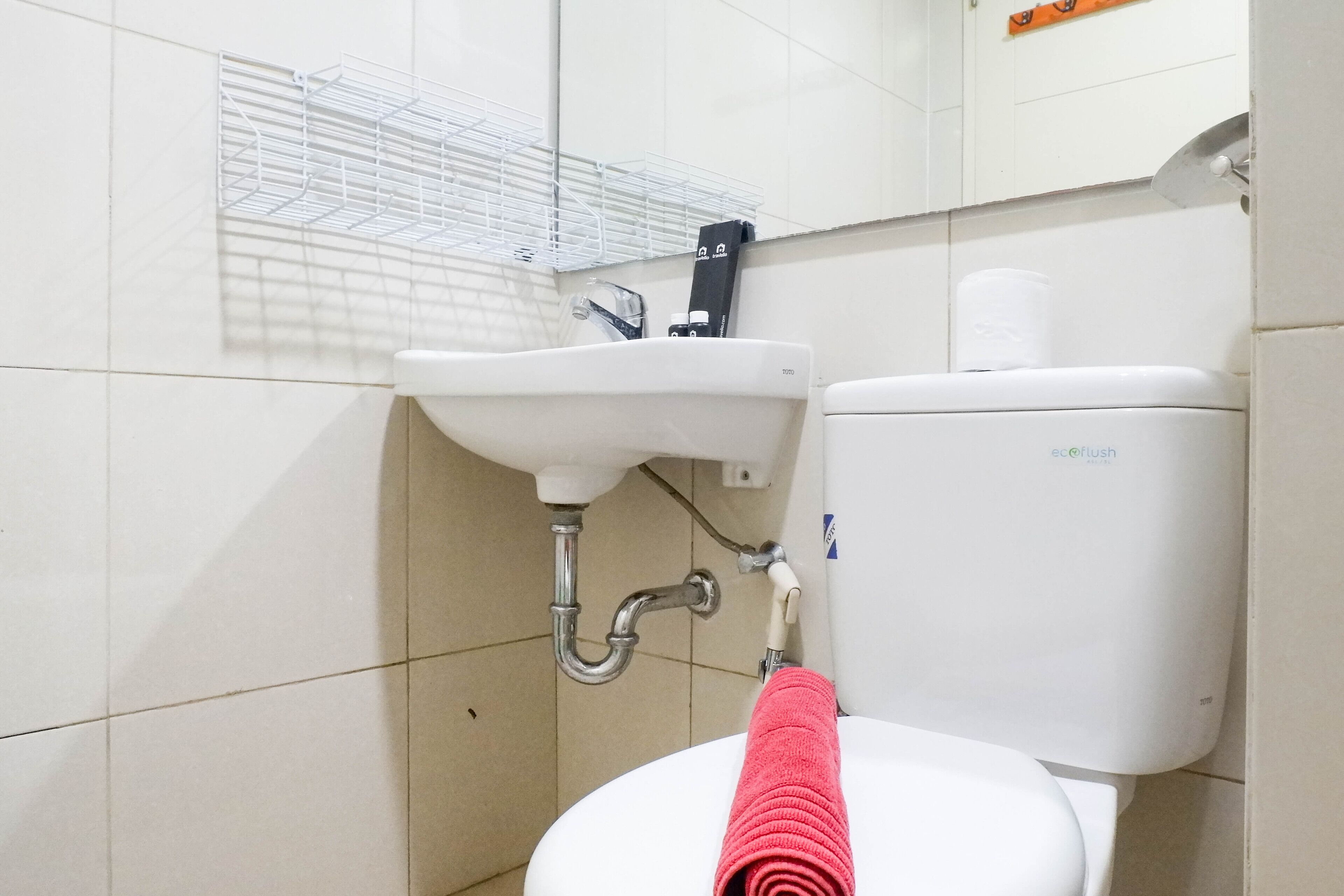A bathroom with a white sink, a toilet, and a towel rack.