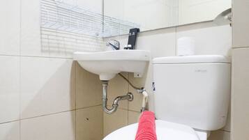 A bathroom with a white sink, a toilet, and a towel rack.