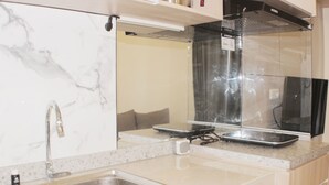 A kitchen with a sink, countertop, and a stove. - Serene And Cozy 2Br At Meikarta Apartment (Cikarang)