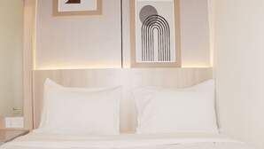 A neatly made bed with white linens in a hotel room. - Serene And Cozy 2Br At Meikarta Apartment (Cikarang)