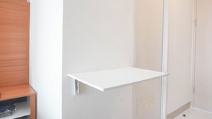 Een witte schapunit bevestigd aan een muur, een houten kast en een deur met een ventilatieopening.