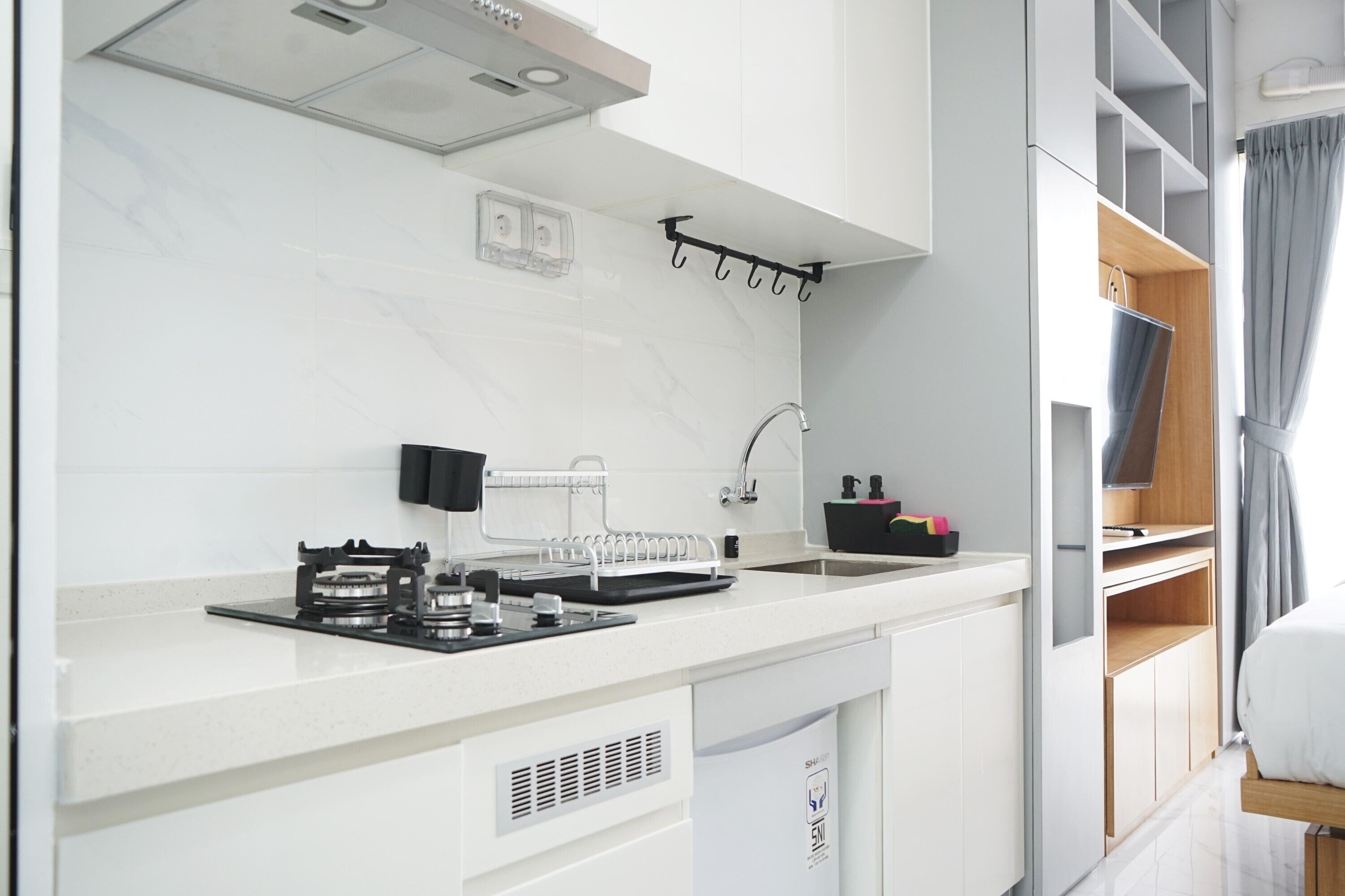 A modern kitchen with a gas stove, sink, and white cabinetry.