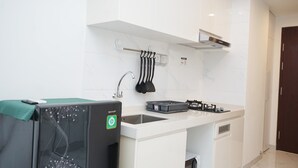 Une cuisine moderne avec des armoires blanches, un évier en acier inoxydable et une cuisinière encastrée.