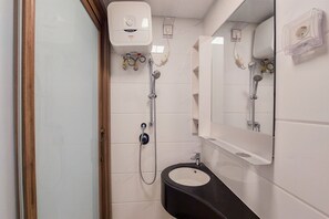 Une salle de bain avec une douche, un lavabo et un miroir.