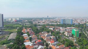 Un paisaje urbano con edificios residenciales, algo de vegetación y unas pocas estructuras altas.