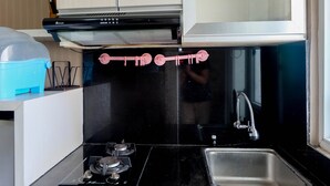Una cocina con cubierta negra, pileta de acero inoxidable y cocina a gas.