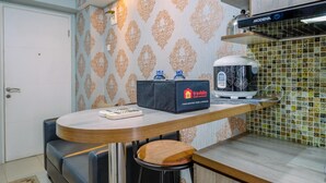 A compact kitchen with a microwave, a travel bag, and a water dispenser on a counter. - Comfort And Strategic 2Br At Bassura City Apartment (Jakarta)