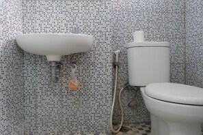 A bathroom with a white sink, toilet, and shower. - Nice And Strategic Studio Kebagusan City Apartment (Jakarta)