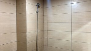 A shower with a handheld showerhead and a flexible hose. - Comfort Studio Room At Margonda Residence 5 Apartment (Depok)