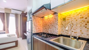 Eine moderne Küche mit Gaskochfeld, Edelstahlspüle und einer gefliesten Spritzschutzwand.