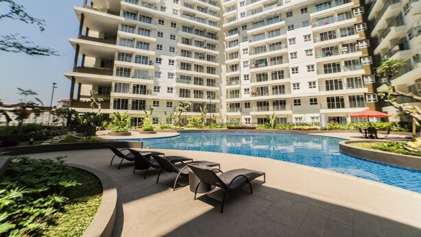 Un moderno edificio de apartamentos con piscina y zona de estar al aire libre.