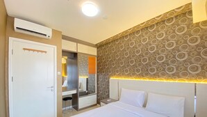 Habitación de hotel con cama, armario, espejo y pared con diseño.
