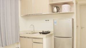 Une cuisine compacte équipée d’un évier, d’une bouilloire, d’une machine à café et d’un réfrigérateur.