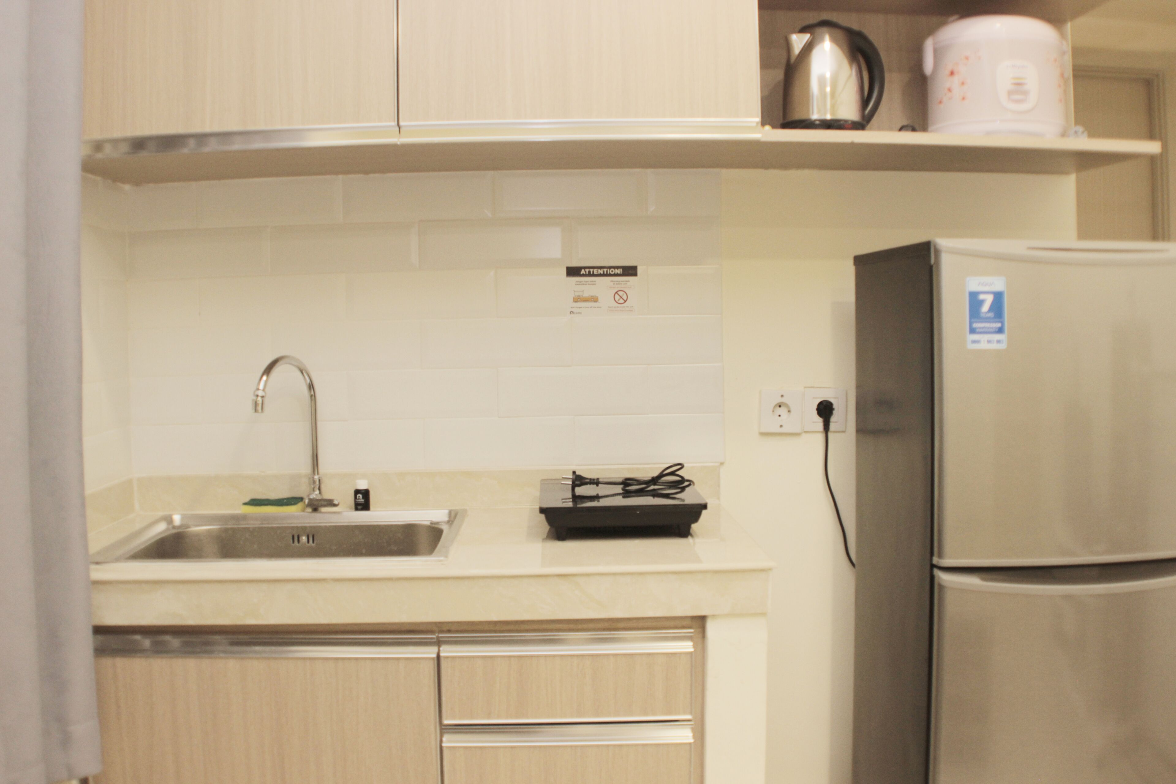 A kitchen with a stainless steel sink, a built-in stove, and a refrigerator.