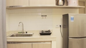 Une cuisine équipée d’un évier en acier inoxydable, d’une cuisinière encastrée et d’un réfrigérateur.