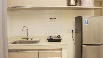 A kitchen with a stainless steel sink, a built-in stove, and a refrigerator.