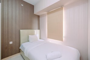 A hotel room with a large bed, a headboard, a window with curtains, and a wall with vertical lines. - Well Designed 2Br Apartment At Springlake Summarecon Bekasi (Bekasi)