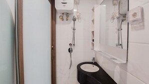 Un baño moderno con un lavamanos negro, un espejo y una ducha.