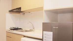 A kitchen with a stainless steel refrigerator, a built-in oven, and a sink.