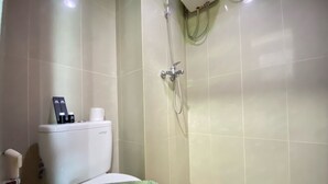 A bathroom with a toilet, a shower, and a bidet. - Affordable Studio Room At Taman Melati Jatinangor Apartment (Hegarmanah)