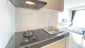 Une cuisine moderne avec un fourneau noir, un évier en acier inoxydable et des armoires en bois.