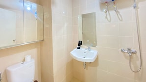 Un bagno con servizi igienici, lavabo, specchio e doccia.