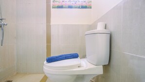 Een badkamer met toilet, douche en decoratief wandpaneel.