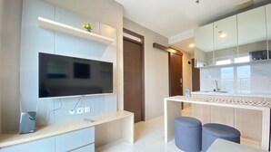 A modern kitchen with a built-in TV, a small dining area, and a large window. - Well Furnished And Private 2Br Mekarwangi Square Cibaduyut Apartment (Bandung)