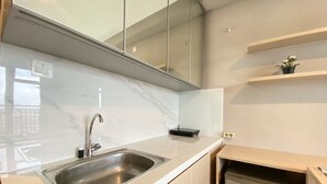 A modern kitchen with a stainless steel sink, a built-in dishwasher, and a marble countertop. - Well Furnished And Private 2Br Mekarwangi Square Cibaduyut Apartment (Bandung)