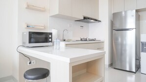 A modern kitchen with a stainless steel refrigerator, a microwave, and a sink. - Nice And Comfort 2Br At Pejaten Park Apartment (Jakarta)